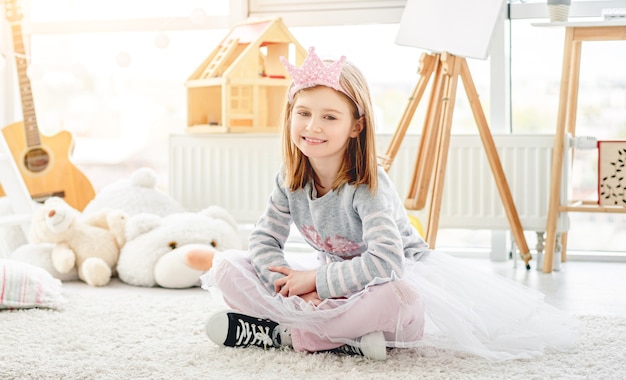 Jolie petite princesse assise dans la chambre des enfants