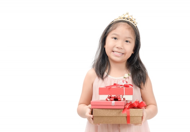 Jolie petite princesse tenant une boîte cadeau rouge isolée