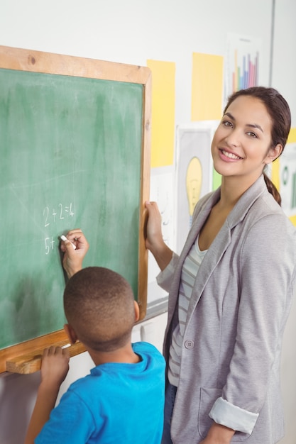 Jolie professeur aidant élève au tableau