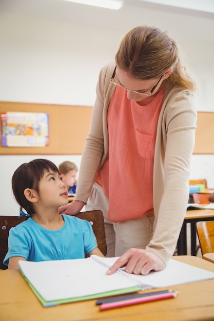 Jolie professeur aidant l&#39;élève en salle de classe