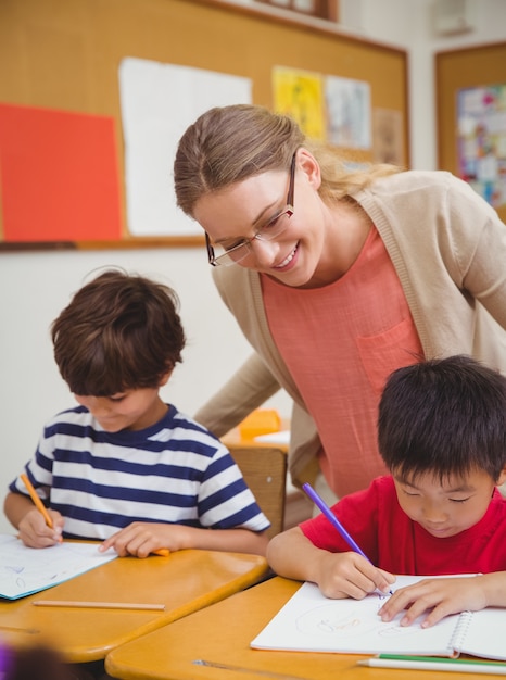 Jolie professeur aidant l&#39;élève en salle de classe