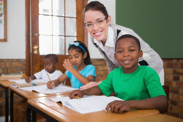 Jolie professeur aidant l&#39;élève en salle de classe