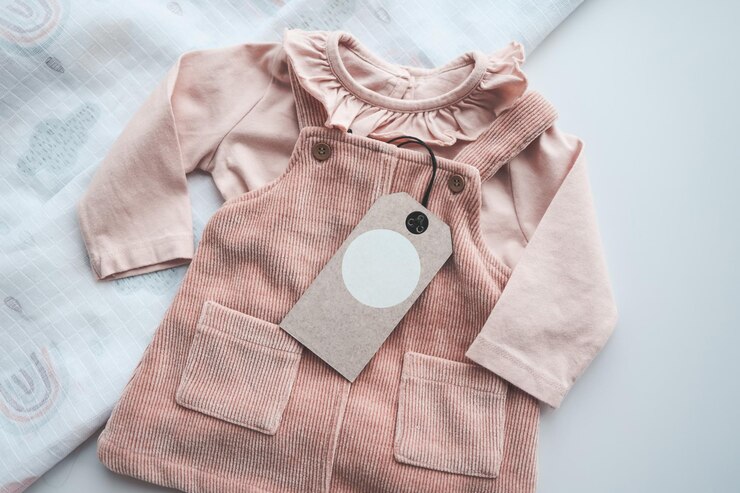 Jolie robe rose bébé avec espace d'étiquette artisanale pour votre logo