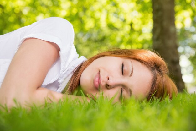 Jolie rousse allongée sur l&#39;herbe