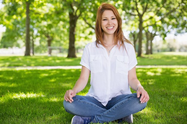 Jolie rousse, souriant à la caméra dans le parc