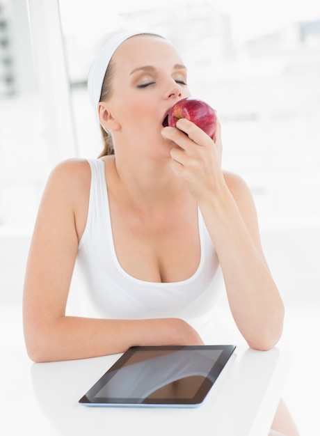 Jolie sportive détendue mangeant une pomme