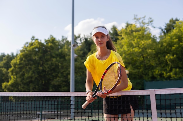 Jolie sportive avec raquette sur le court de tennis Mode de vie sain