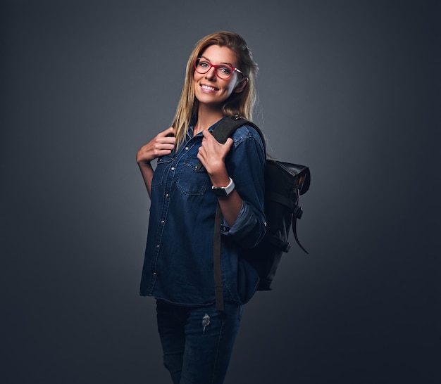 Jolie voyageuse urbaine vêtue d'une chemise en jean et d'un jean.