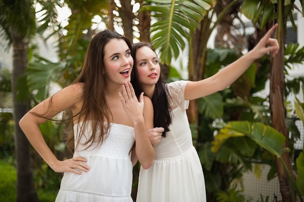 Jolies amies souriantes en robes blanches