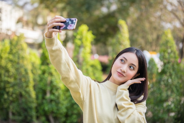 De Jolies Femmes Asiatiques Utilisent Leurs Téléphones Pour Prendre Des Selfies Et Sourire Heureux Dans Le Jardin à La Maison.