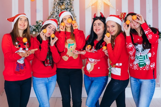 Jolies femmes avec des pulls rouges célébrant Noël