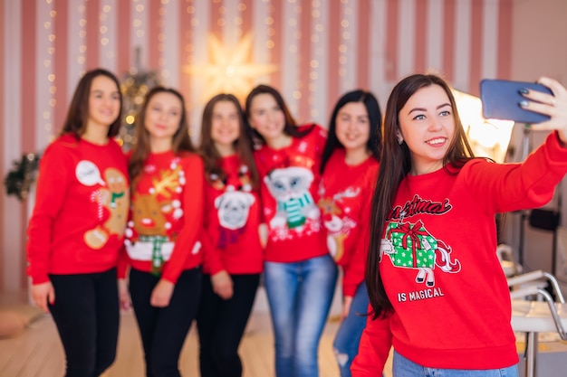 Jolies femmes avec des pulls rouges célébrant Noël