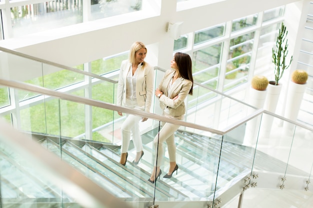 Jolies jeunes femmes dans les escaliers au bureau