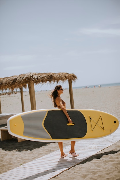 Jolies jeunes femmes avec paddle board sur la plage un jour d'été