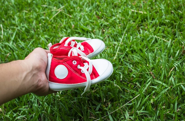 Jolies petites chaussures en toile rouges sur l'herbe