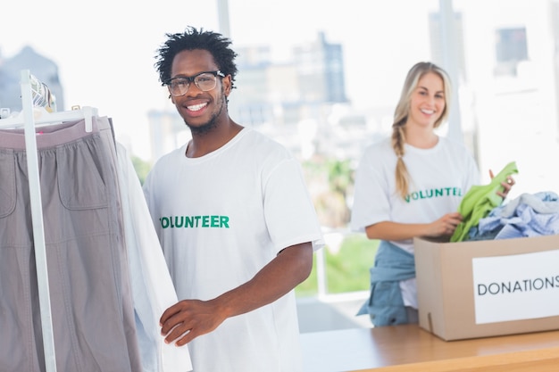 Photo de jolis bénévoles sortent des vêtements d'une boîte à dons