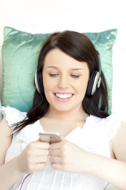 Jolly jeune femme écoute de la musique avec des écouteurs