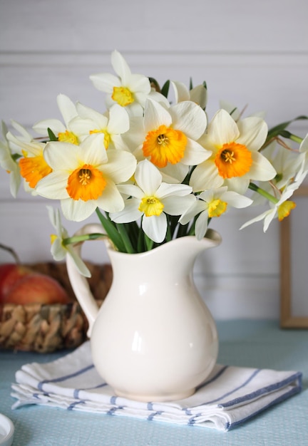 Jonquilles dans une cruche sur la table à l'intérieur du chalet