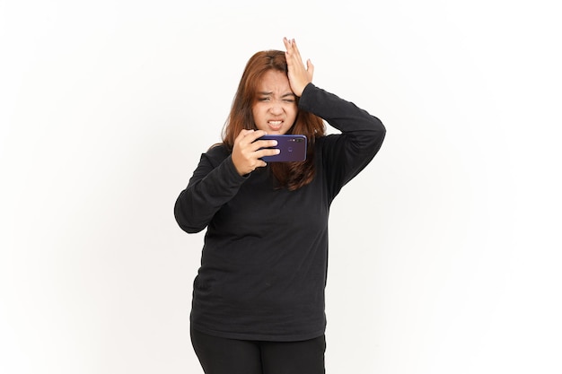 Jouer au jeu mobile sur smartphone de la belle femme asiatique portant une chemise noire isolée sur blanc