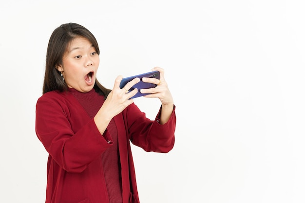 Jouer au jeu mobile sur Smartphone de la belle femme asiatique portant une chemise rouge isolée sur blanc