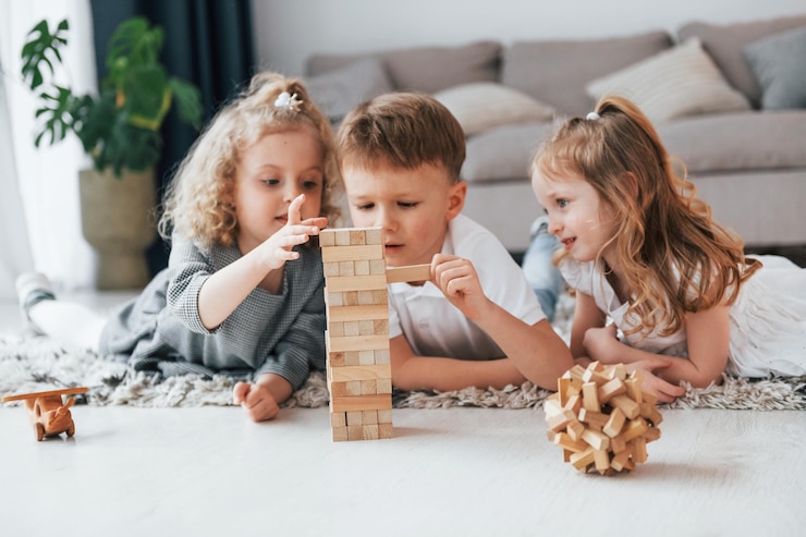 Photo jouer au jeu de la tour en bois un groupe d'enfants est ensemble à la maison pendant la journée
