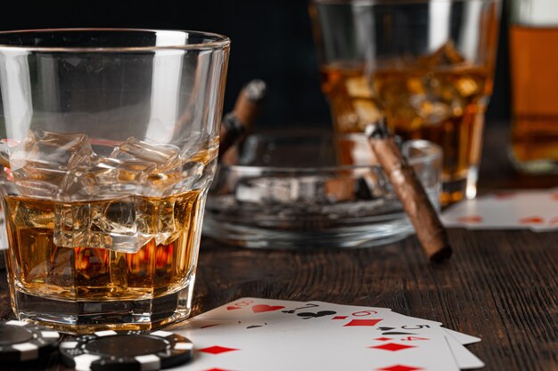 Jouer au poker avec du whisky et des cigares sur table