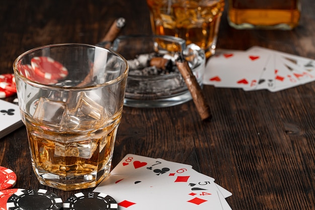 Jouer au poker avec du whisky et des cigares sur table