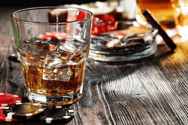 Jouer au poker avec du whisky et des cigares sur table