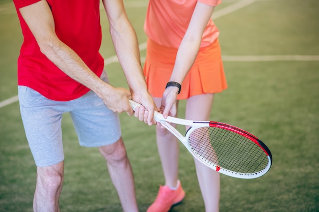 Jouer au tennis. Gros plan photo d'homme et femme tenant une raquette