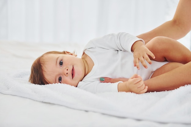 Jouer autour de la mère avec sa petite fille est à l'intérieur à la maison ensemble