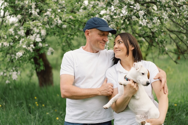 Jouer en famille au chien Jack Russell Terrier dans le pré. Family hugging Jack Russell Terrier chien dans la nature.