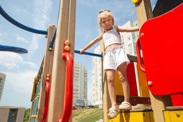 jouer fille caucasienne dans la cour du jardin d'enfants