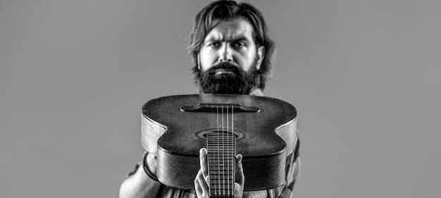 Jouer de la guitare Guitares et cordes Homme barbu jouant de la guitare tenant une guitare acoustique dans ses mains Noir et blanc