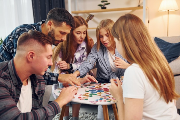 Jouer à un jeu intelligent Un groupe d'amis fait la fête ensemble à l'intérieur