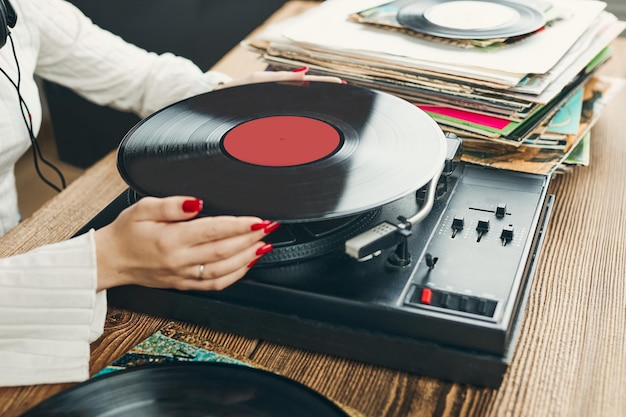 Photo jouer de la musique à partir d'un disque vinyle, d'une disque analogique, de style rétro et vintage, écouter de la musique sur un disque lp