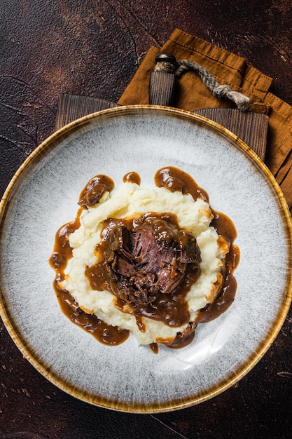 Joues de boeuf cuites lentement dans une sauce au vin rouge avec purée de pommes de terre Fond sombre Vue de dessus