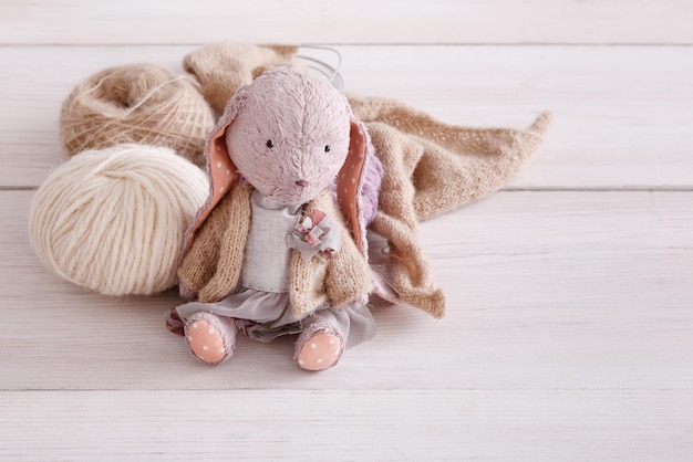 Jouet ancien. Lapin fait main mignon avec de la laine se bouchent. Chose en peluche avec des matériaux, copiez l'espace. Créativité, artisanat, concept de passe-temps