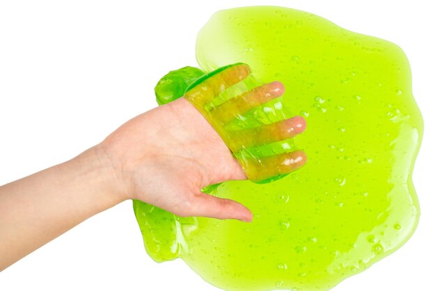 Photo jouet de boue verte dans la main de femme isolée sur blanc. vue de dessus.