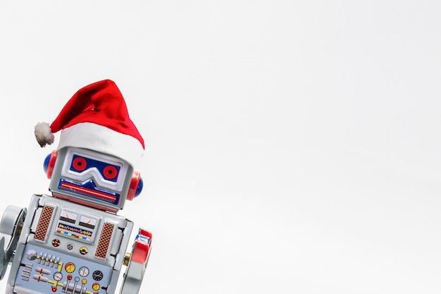 Jouet classique rétro robot vintage avec un chapeau de Noël sur fond blanc