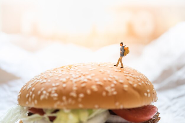 Jouet figure figurine voyageur marchant sur le burger de bœuf.