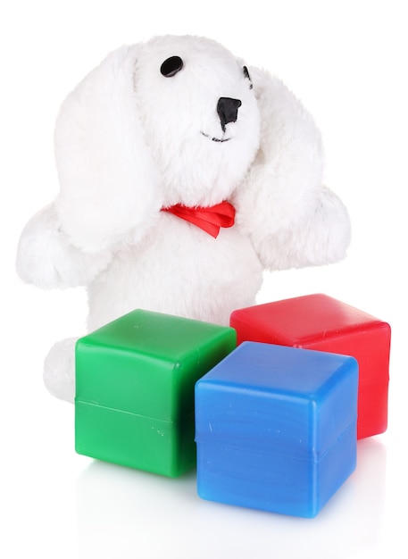 Jouet lapin assis et cubes de couleur isolés sur blanc