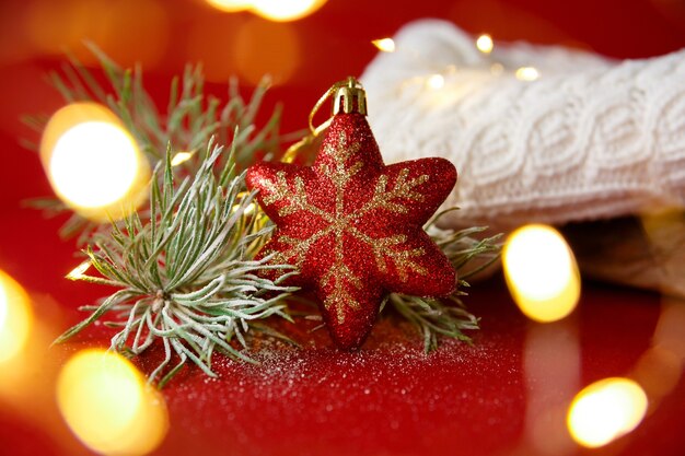 Jouet de Noël et branche de sapin dans la neige avec pull blanc tricoté et guirlande