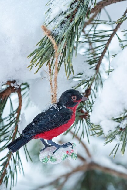 Jouet de Noël oiseau de style rétro suspendu sur épicéa et sur arrière-plan flou