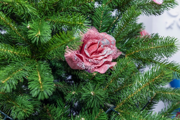 Jouet de Noël rose sur les branches d'un arbre de Noël artificiel.