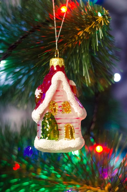 Jouet de Noël sous forme de maison sur un arbre de fête