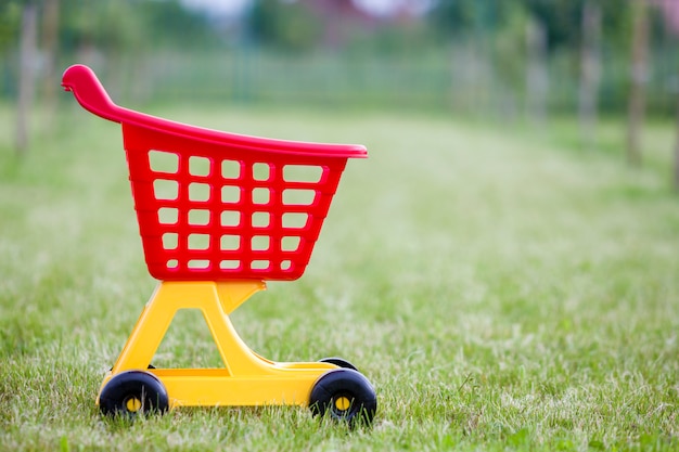 Jouet de panier shopping coloré en plastique brillant à l'extérieur sur une journée d'été ensoleillée