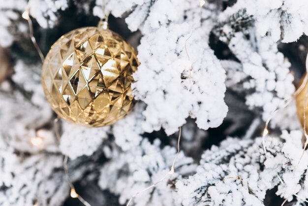 Jouet rond en or sur le sapin de Noël. Concept de Noël et du nouvel an