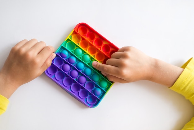 Jouet sensoriel anti-stress coloré fidget push pop it dans les mains de l'enfant