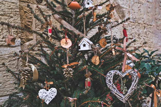 Les jouets en bois, les bonbons, les boules en cuir, les pommes de pin et les fruits secs sont des décorations naturelles pour le sapin de Noël.