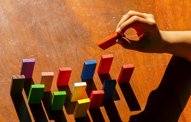 Jouets en bois colorés, jouets logiques éducatifs pour les enfants avec la main des enfants en gros plan, au soleil du matin